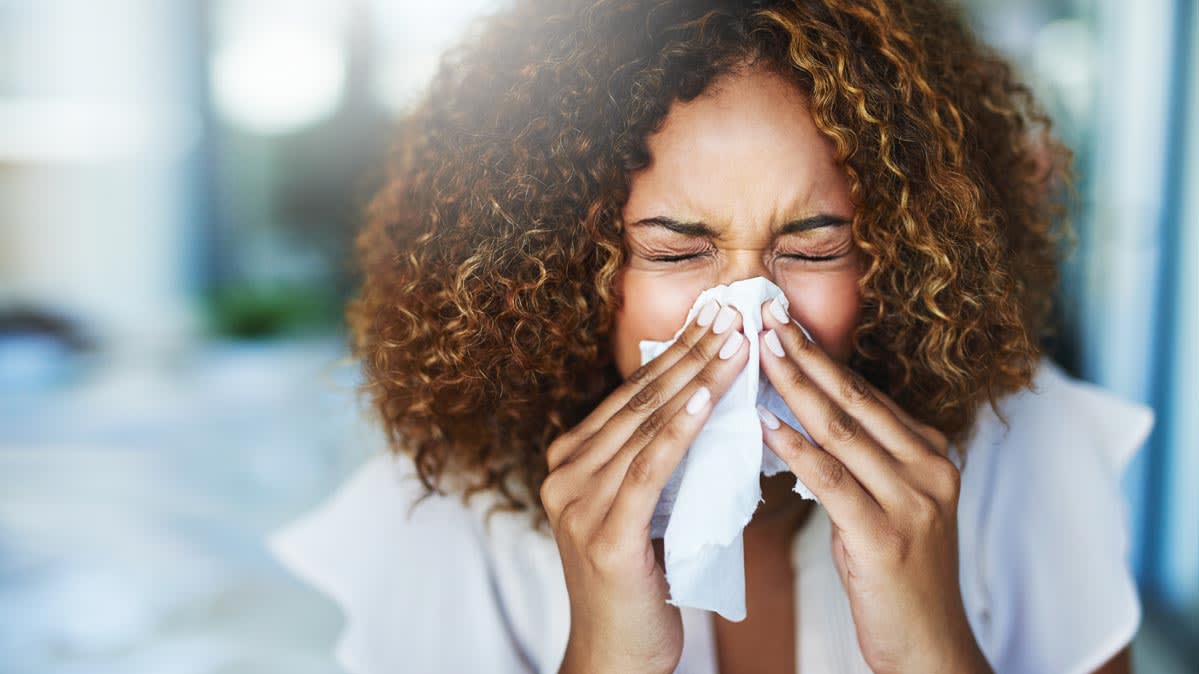 A woman sneezing into a tissue - Incense Route